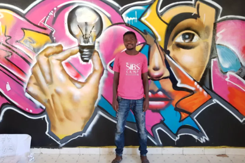 Anami Daudi of Mukuru Social Justice Centre. The mural depicts that HRDs are the light and eyes of the community